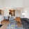 Spacious living room with dark wood floors and large windows that leads out to a patio