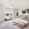 large bedroom with oversized windows, queen bed and seating area